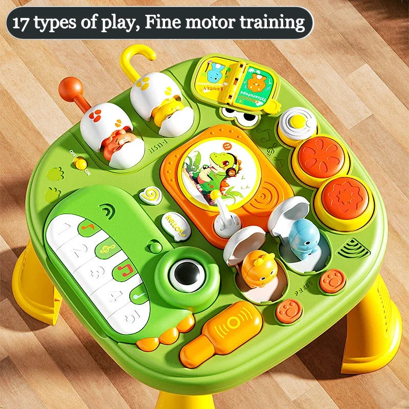 Top view of the activity table showing piano keys, drum pads, a flip book, and colorful buttons
