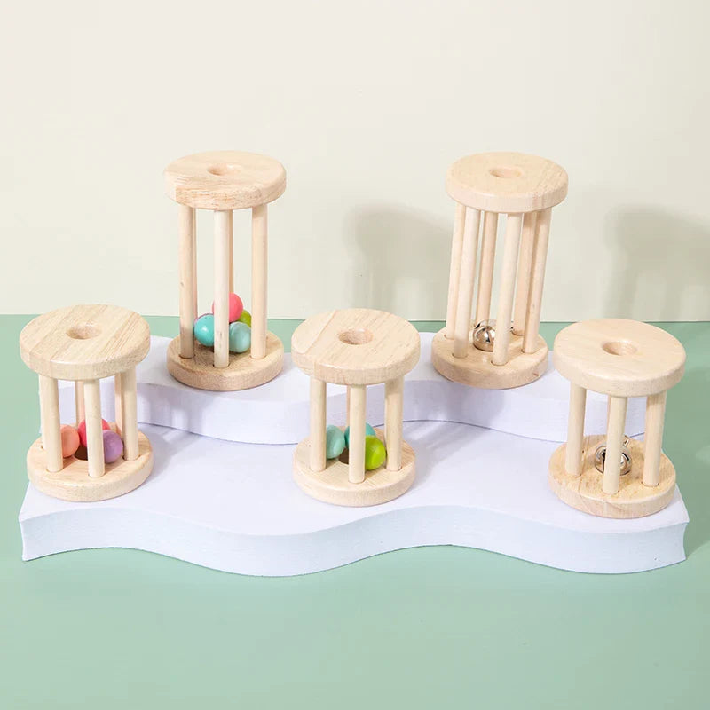 Five wooden cage rattles with balls or bells on a tiered white stand