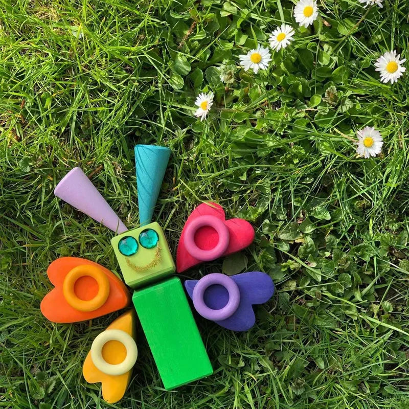 Colorful wooden shapes arranged as a butterfly on grass