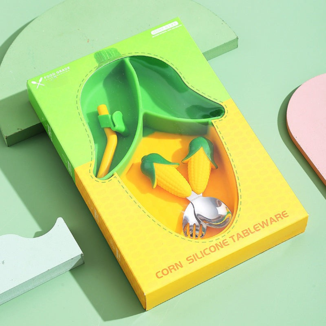 Green-and-yellow corn-shaped plate with matching cutlery and straw in a windowed box
