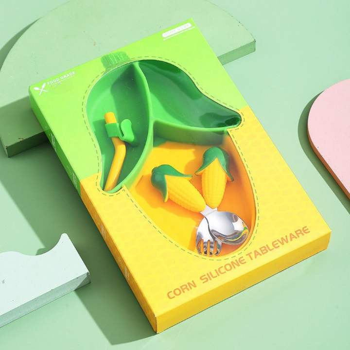 Green-and-yellow corn-shaped plate with matching cutlery and straw in a windowed box