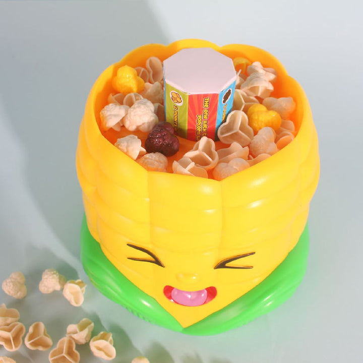 Toy popcorn pieces and a die inside the corn-shaped game unit