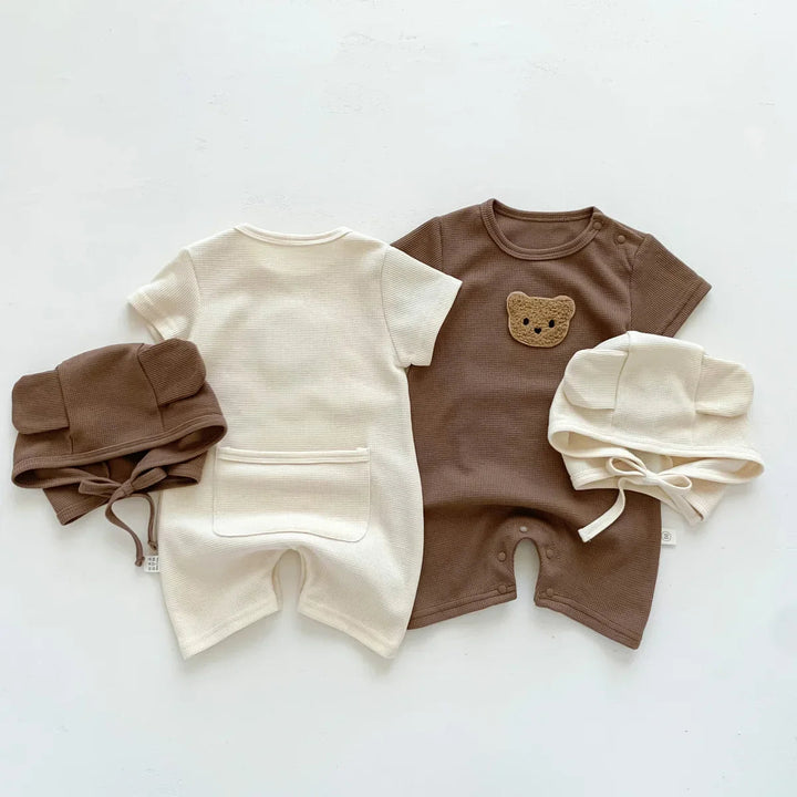 Back of beige baby romper and front of brown bear romper, shown with matching hats