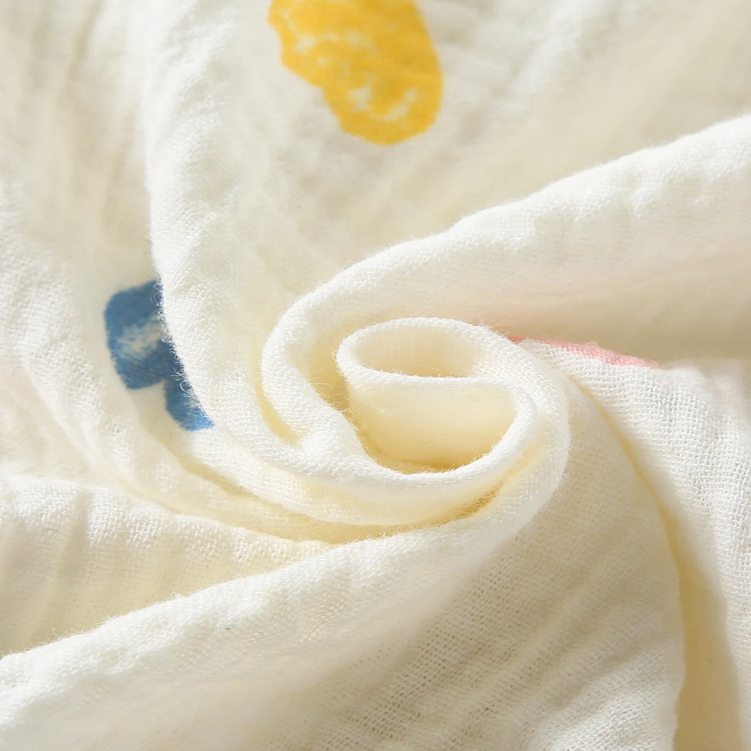 Close-up of textured cotton fabric with yellow and blue heart prints