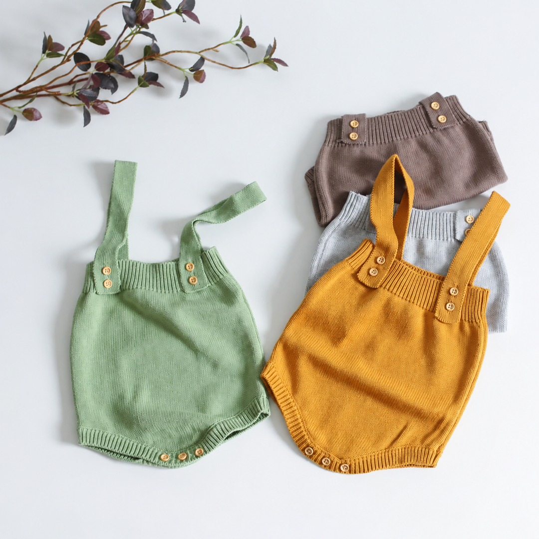 Green, mustard yellow, gray, and taupe knit baby rompers with buttoned shoulder straps