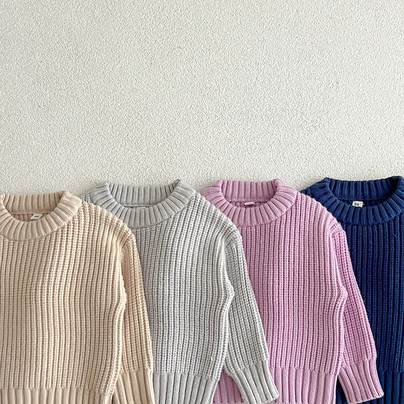 Close view of ribbed necklines and long sleeves on apricot, gray, purple, and dark blue sweaters.
