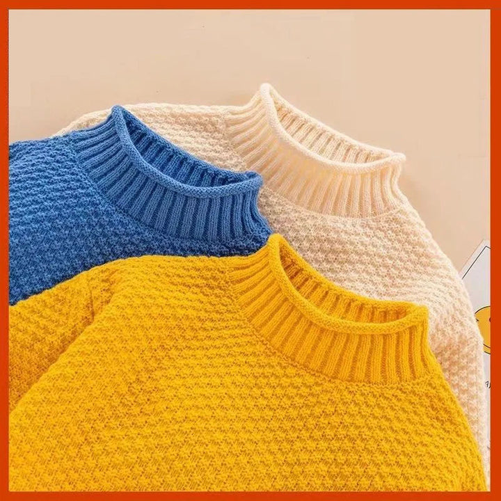 Close-up of ribbed necklines and textured knit on blue, cream white and yellow sweaters.