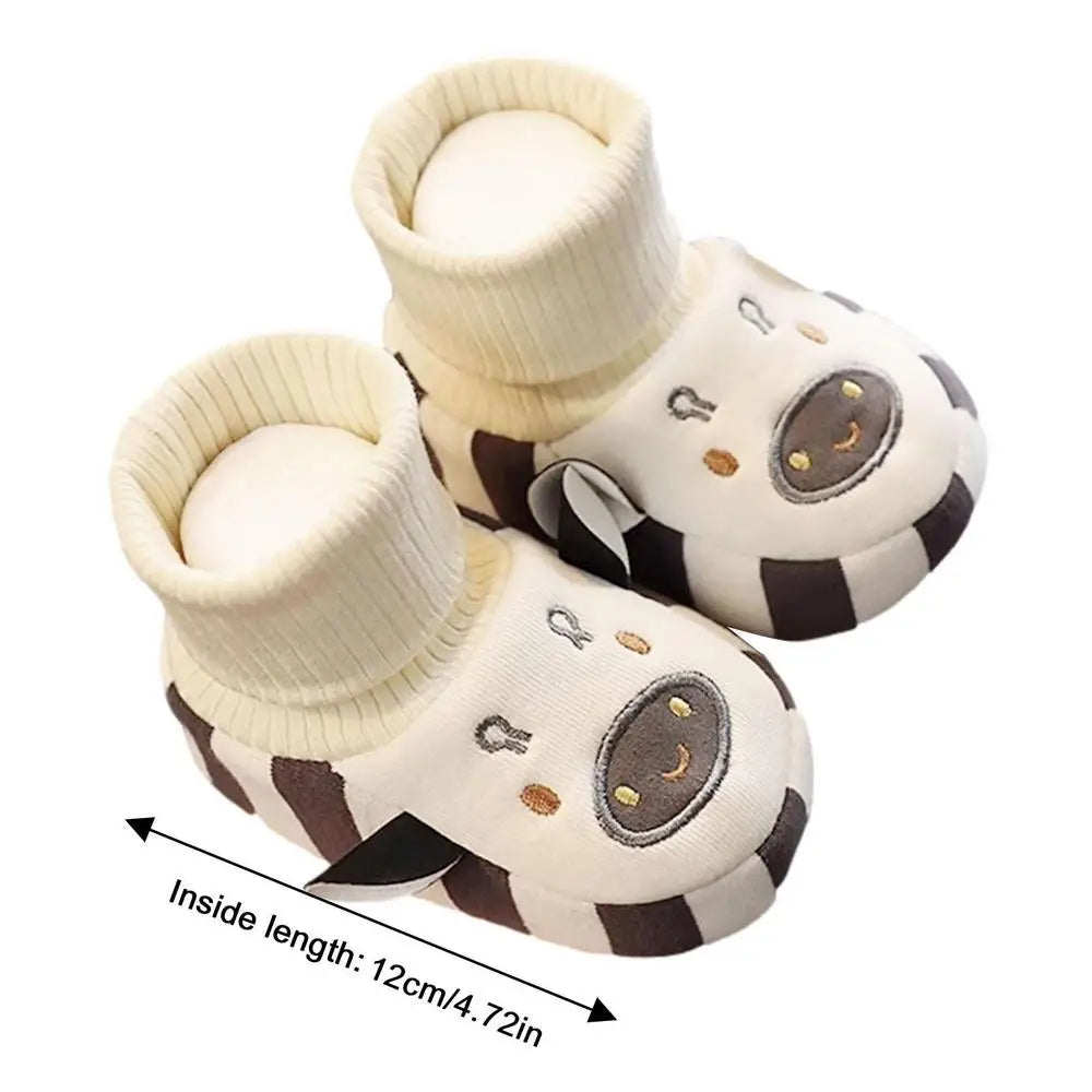 Cream cow indoor shoes with an inside-length measurement arrow