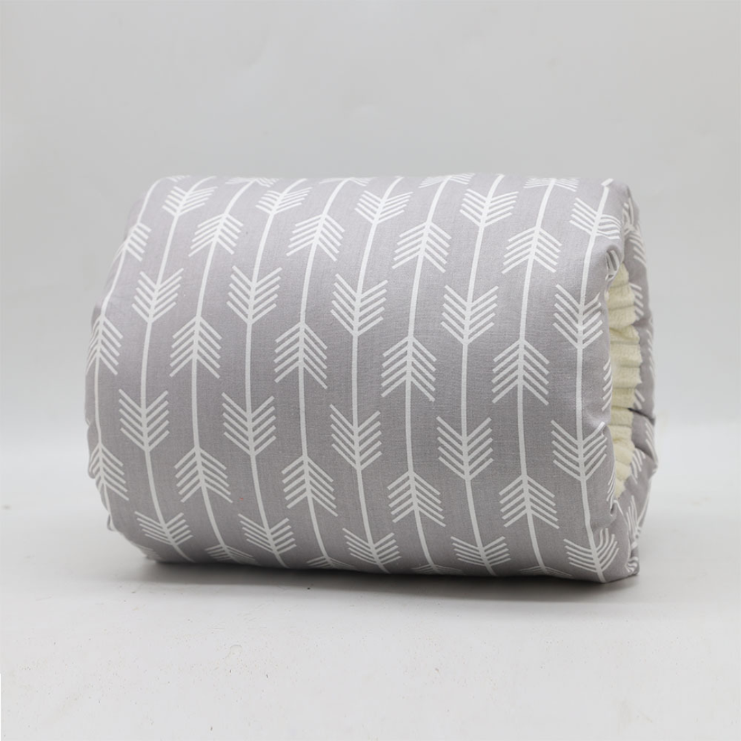 Gray nursing pillow covered in white arrow motifs.