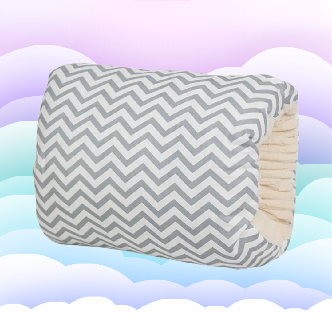 Gray-and-white chevron nursing pillow with an opening that slips over the arm.