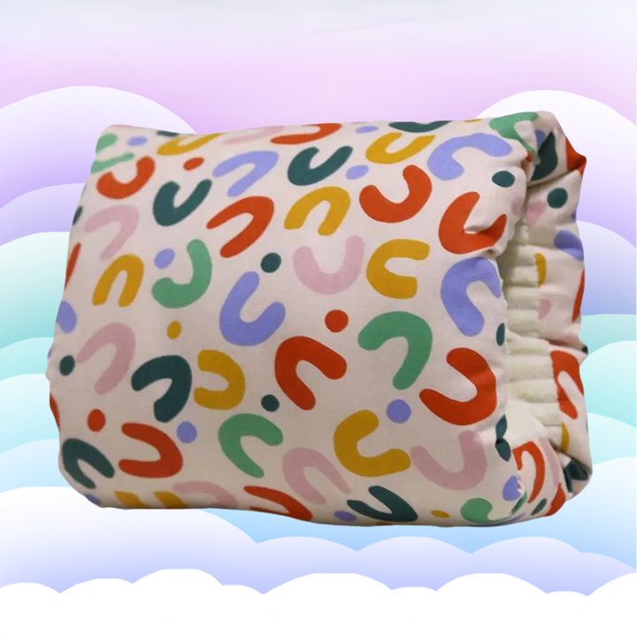 Nursing pillow with a multicolored rainbow pattern and an arm opening.