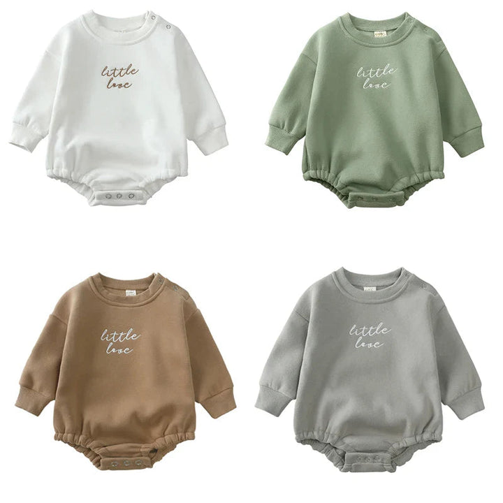 Cotton baby rompers in white, green, brown, and gray with long sleeves and embroidered chest lettering
