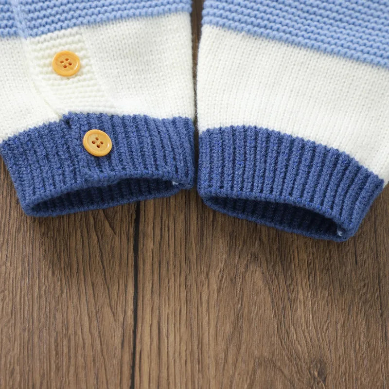 Close-up of blue and white knitted romper leg cuffs with small buttons