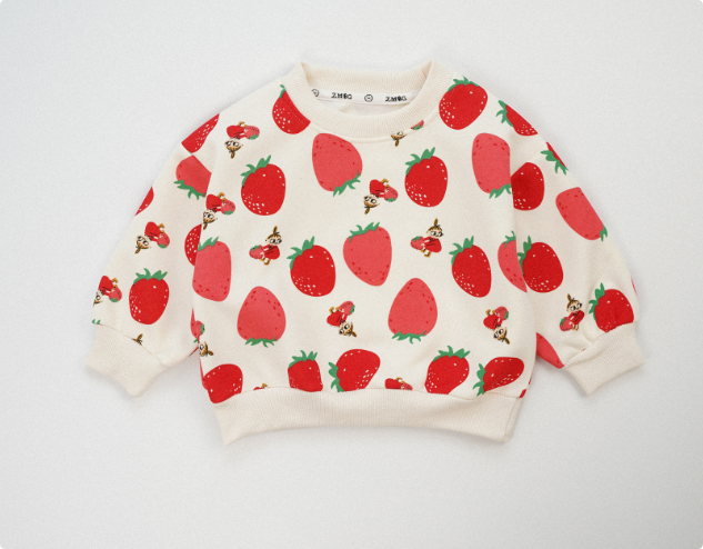 Cream kids' sweater with an allover red strawberry print and ribbed neckline, cuffs, and hem