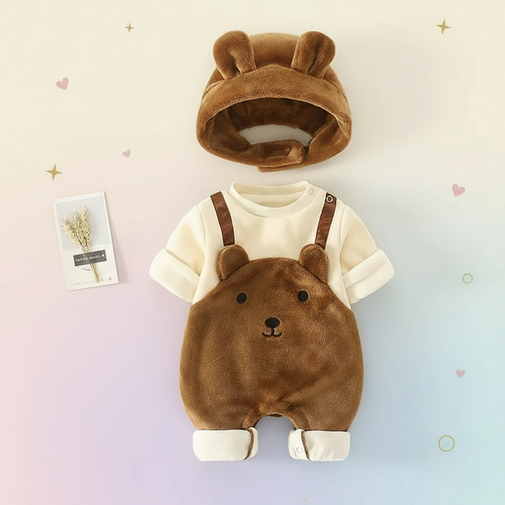 Brown bear-face romper with cream sleeves and a matching hat arranged on a pastel background