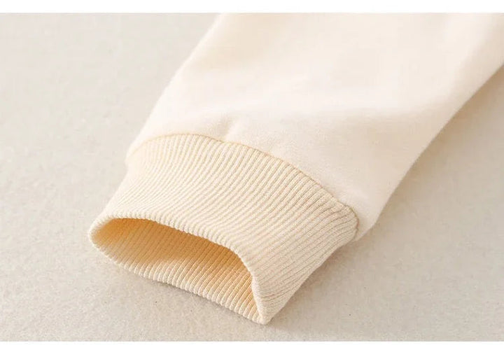 Cream sleeve with a ribbed cuff on the baby jumpsuit