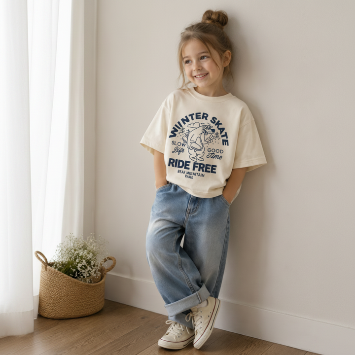 Girl wearing the cream skate bear T-shirt with cuffed jeans and sneakers