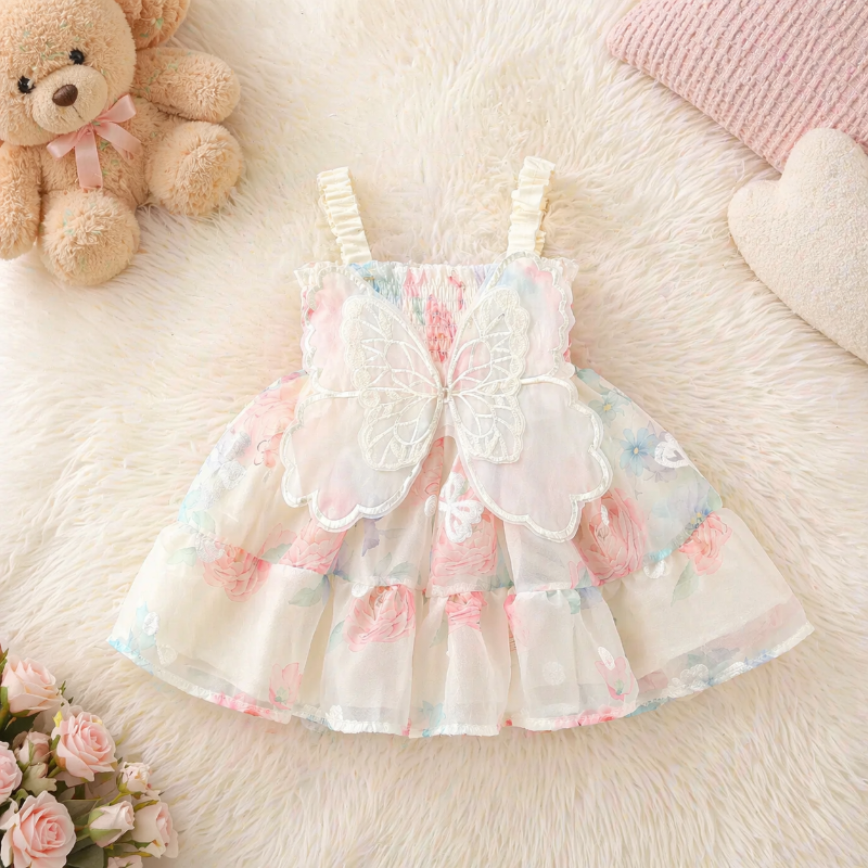 Cream butterfly baby dress laid flat, showing the floral skirt and back wings