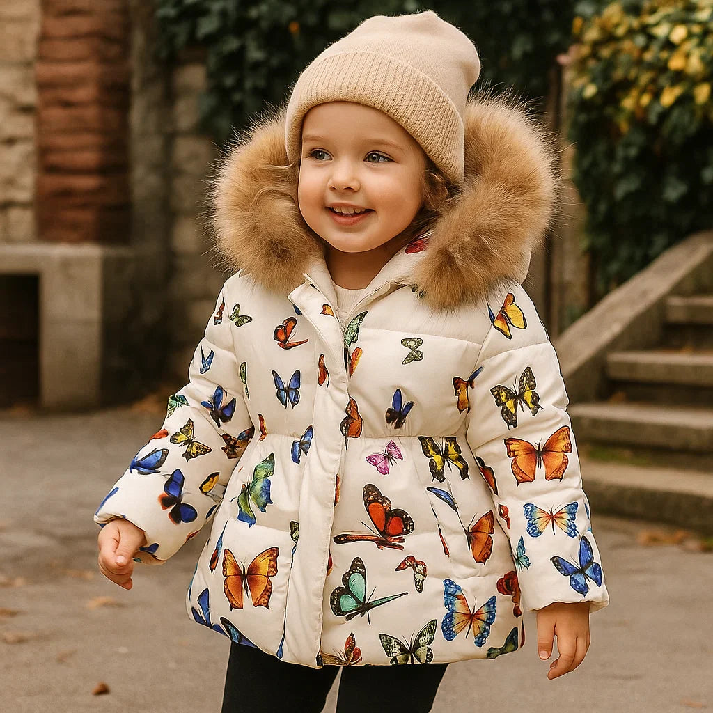 Child wearing a cream butterfly-print quilted coat with a knit hat beside outdoor steps