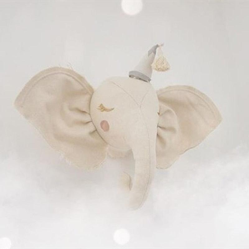 Cream plush elephant wall decoration with pink cheeks and a tasseled hat