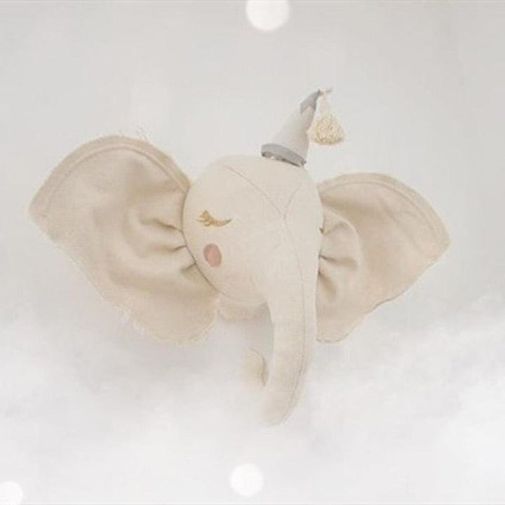 Cream plush elephant wall decoration with pink cheeks and a tasseled hat