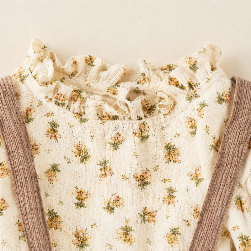 Ruffled neckline on the cream blouse with a small floral print