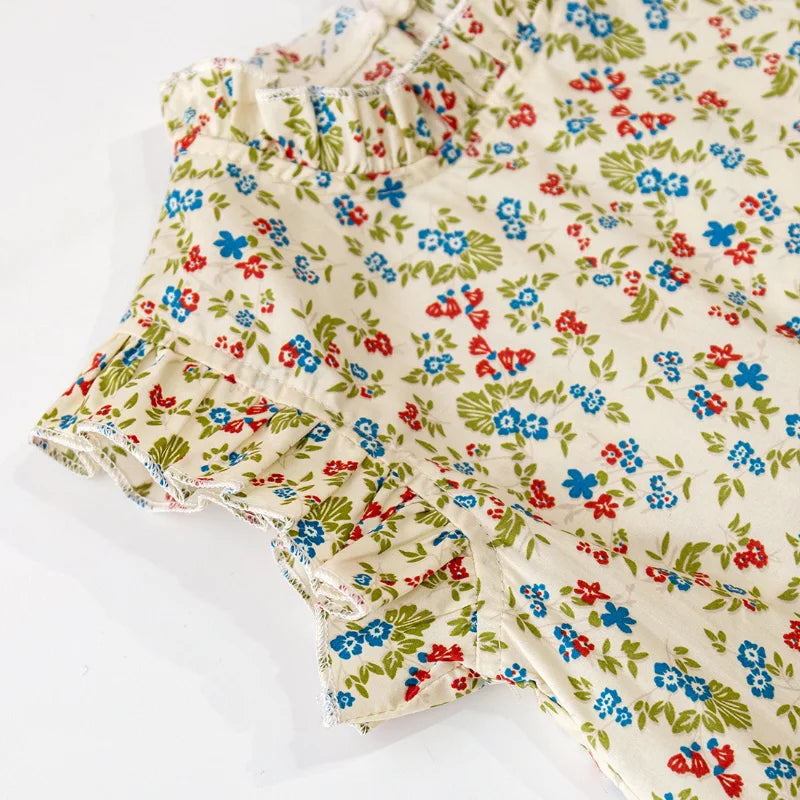 Ruffle-trimmed armhole and small flowers on the cream-colored top