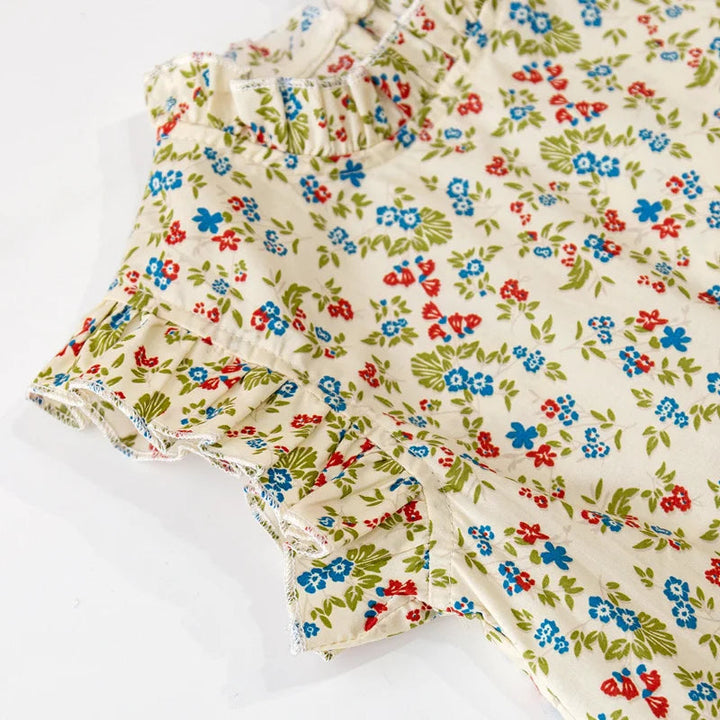 Ruffle-trimmed armhole and small flowers on the cream-colored top