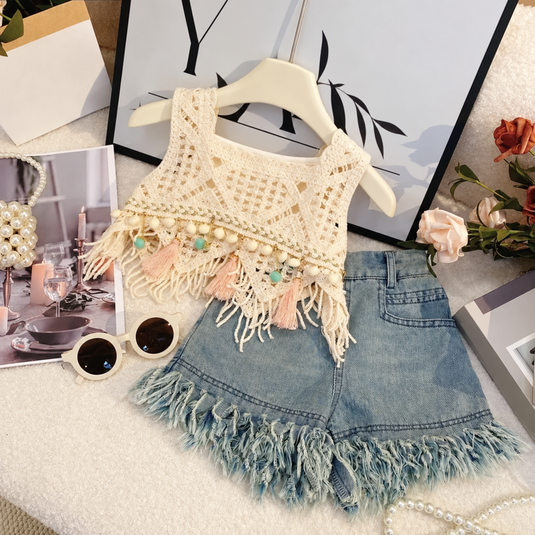 Two-piece outfit with a cream open-knit top, pastel tassels, and blue denim shorts