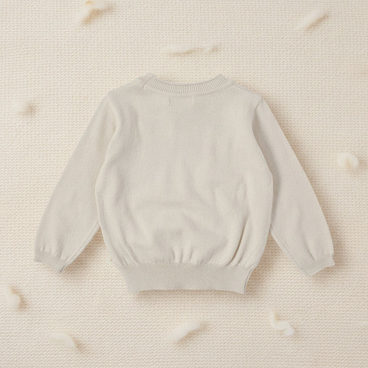 Cream long-sleeve sweater laid flat with a ribbed neckline, cuffs, and hem