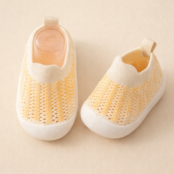 Cream mesh sneakers with pale orange vertical stripes and white soles.