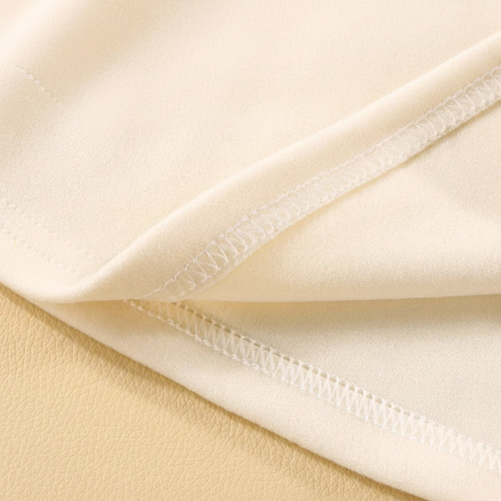 Cream polar fleece fabric close-up showing a stitched seam.