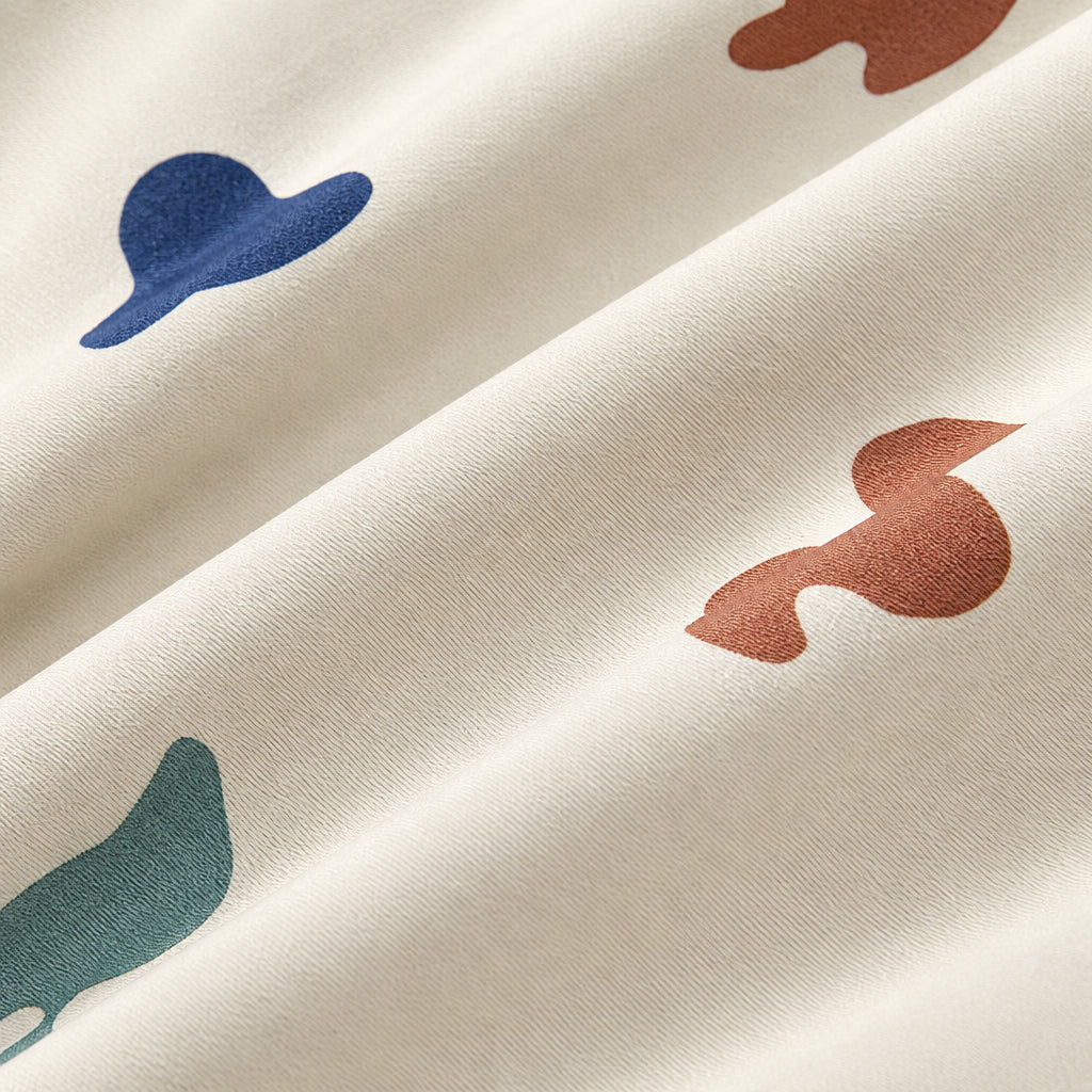 Cream rain jacket fabric with blue, teal and rust-colored abstract shapes.