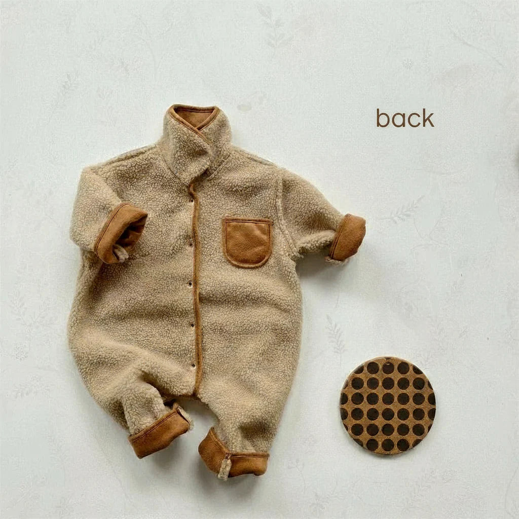 Reversible baby romper with the cream fleece side out and brown chest pocket and cuffs