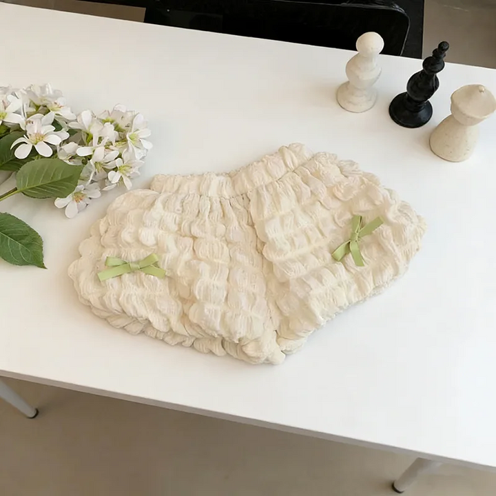 Cream ruffle shorts with green bows and an elastic waistband