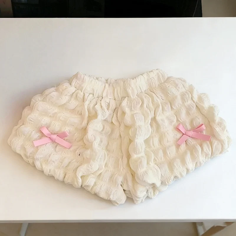 Cream ruffle shorts with pink bows and a gathered waistband