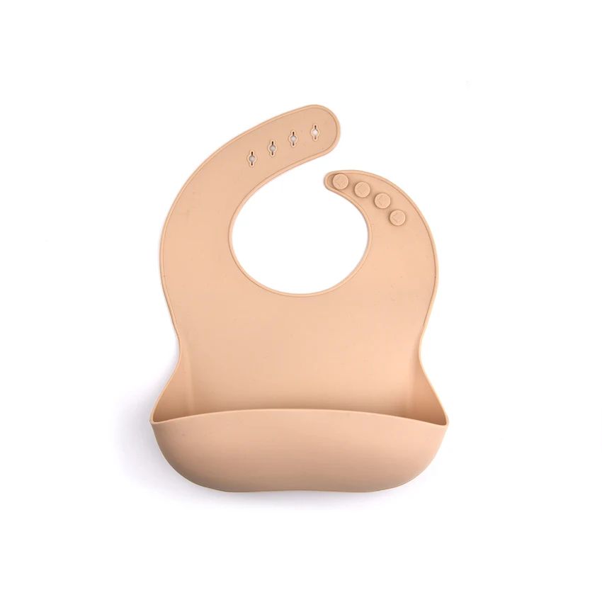 Cream silicone bib with a rounded front pocket and adjustable snap closure.