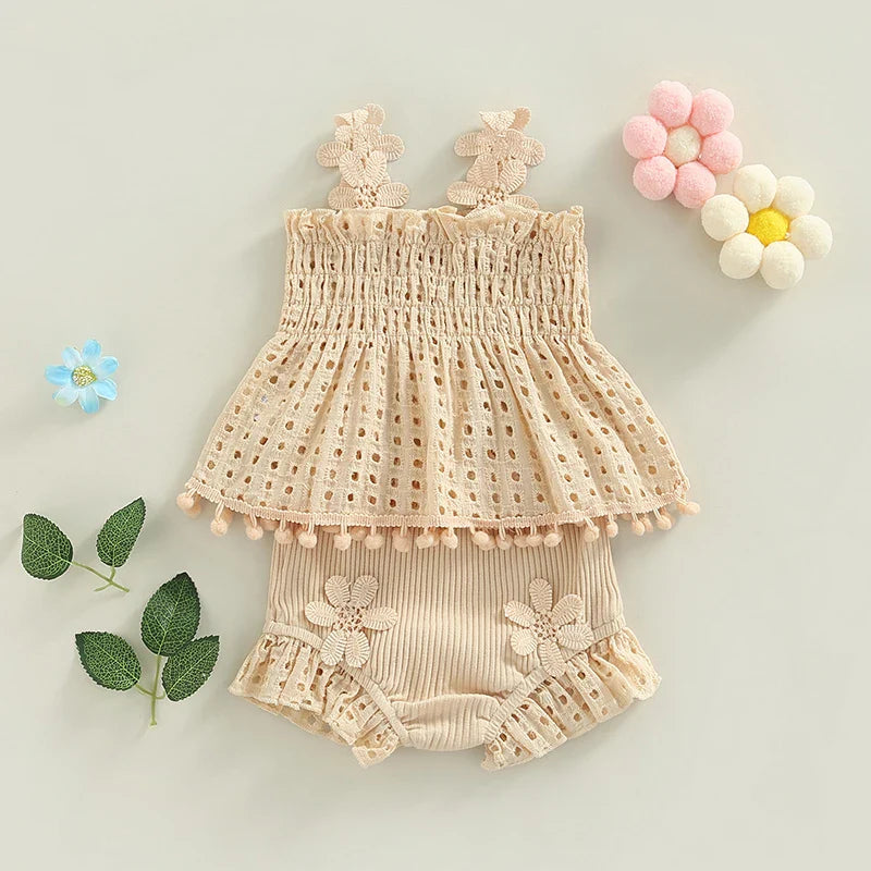Cream two-piece baby outfit with a flared eyelet top and flower-trimmed shorts