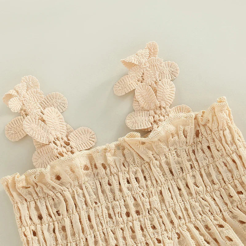 Flower-shaped straps and smocked eyelet bodice on the cream baby top