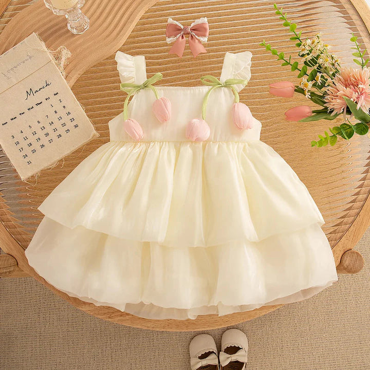 Cream tulip mesh dress with ruffled straps and green ribbon accents