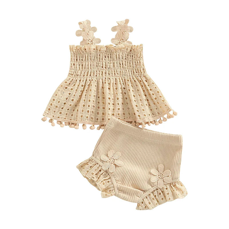 Cream baby top and shorts set with floral straps and ruffled trim on a white background