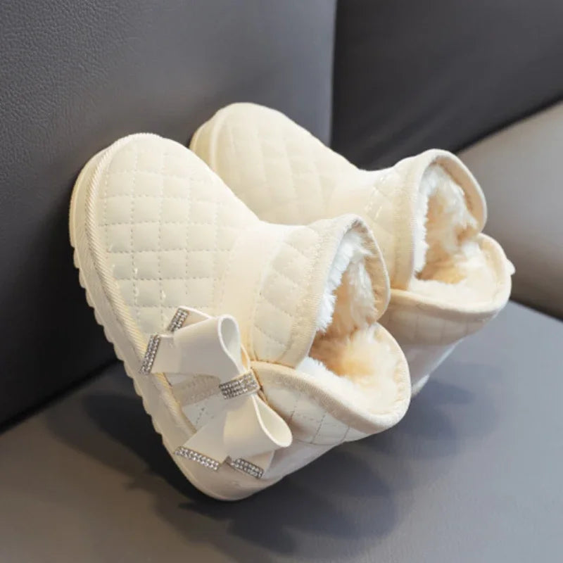 Cream white winter boots tilted to show their plush lining and quilted uppers