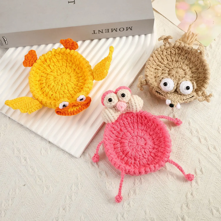 Yellow duck, pink bird, and beige animal coasters with round crocheted centers