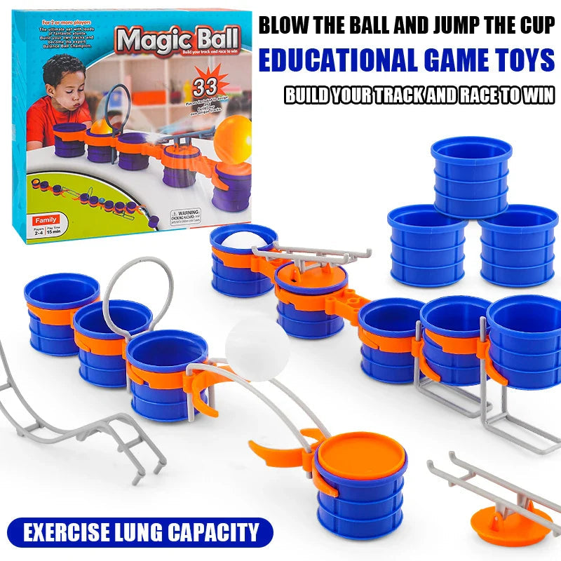 Cup-and-ball game set with blue cups, white balls, orange connectors, gray obstacles and packaging