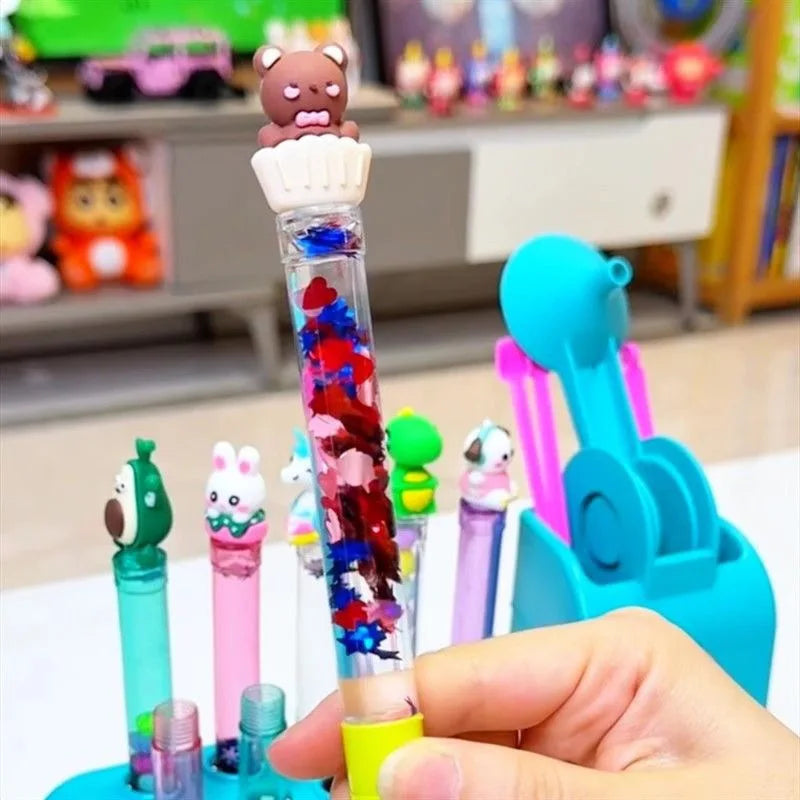 Clear pen filled with colorful sequins and topped with a bear in a cupcake