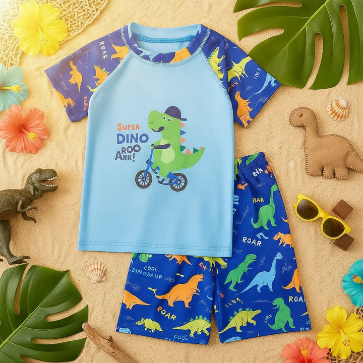 Cycling dinosaur swim shirt and shorts arranged on sand with leaves and toy dinosaurs