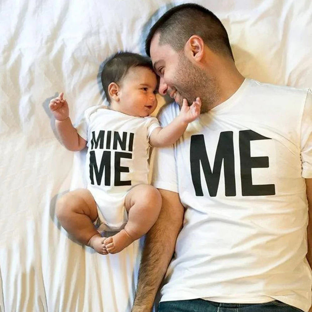 Dad and baby lying together in a white Me T-shirt and coordinating Mini Me bodysuit