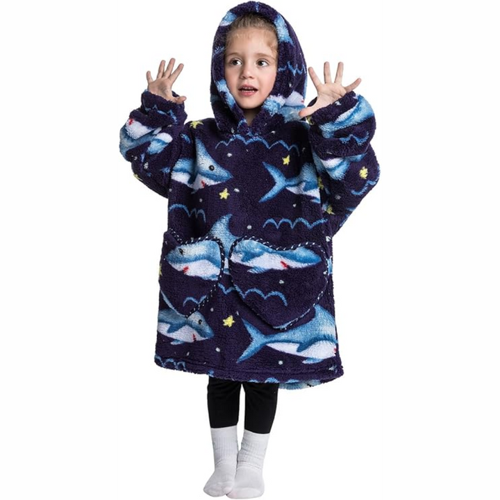 Child wearing a dark blue shark-print hooded blanket with the hood up