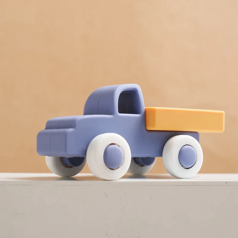 Dark blue silicone toy truck with a yellow bed and white wheels