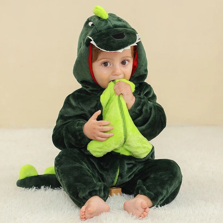Baby in a dark green dragon onesie with a bright green belly and spiked tail